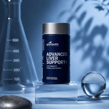 A dark blue bottle of Good Health Advanced Liver Support+ dietary supplement displayed on a clear acrylic pedestal, with a blue laboratory background featuring a beaker and shadow play.