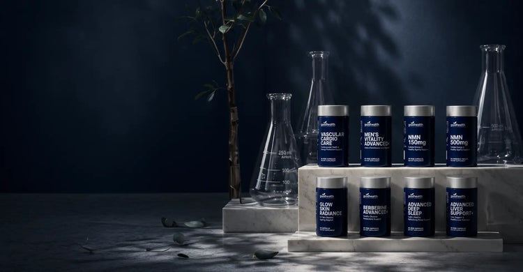 A set of dark blue supplement jars with silver lids arranged on white pedestals alongside clear glass flasks against a dark studio background with dramatic lighting.